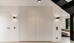 Minimalistische weiße Garderobe, die in der Wand verbaut ist