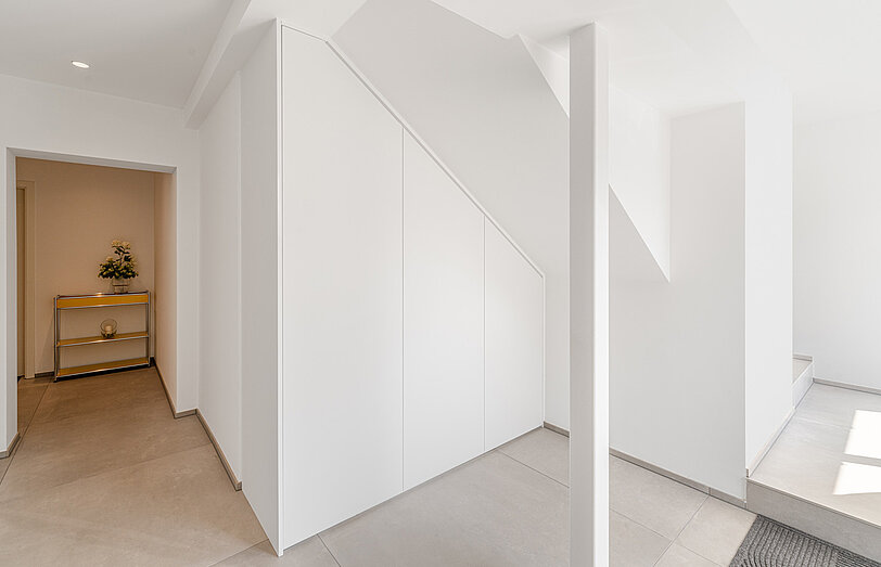 Weißer Garderobenschrank nach Maß unter einer Dachschräge