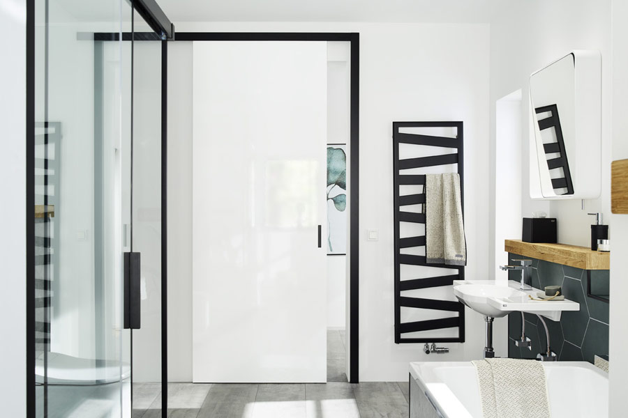 Weiße minimalistische Tür mit schwarzem Türrahmen im Badezimmer eingebaut