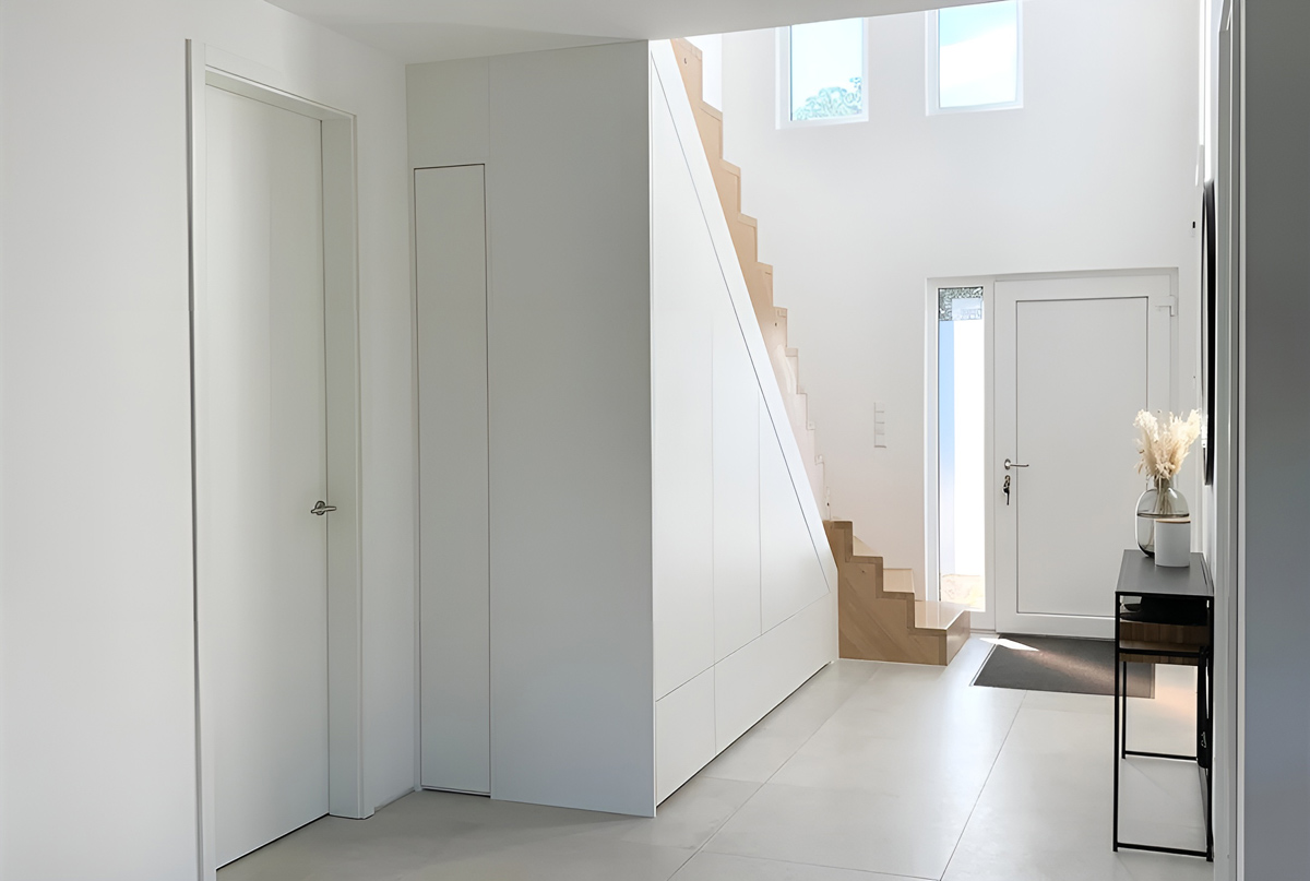 minimalistischer Schrank unter der Treppe in weiß