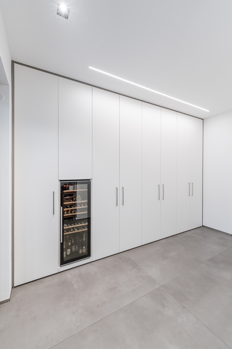Ein stilvoller Einbauschrank in strahlendem Weiß mit integriertem Weinregal – die perfekte Verbindung von Funktionalität und Eleganz für Weinliebhaber.
