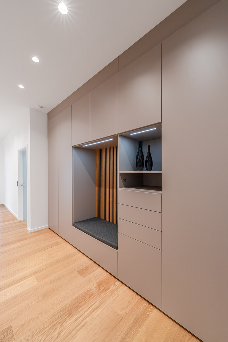 Seitenansicht einer Garderobe, die eine integrierte Sitzbank sowie ein Freifach besitzt