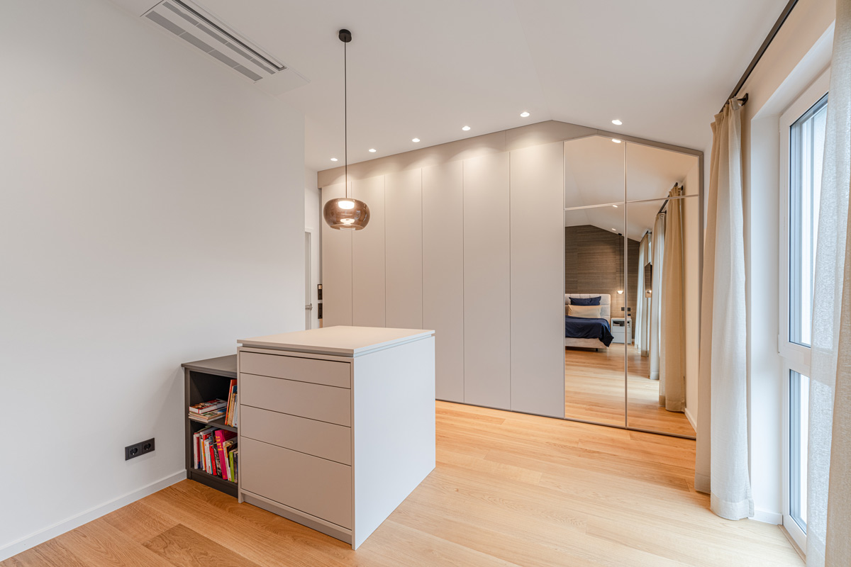 Minimalistischer Kleiderschrank für die Dachschräge mit integriertem Spiegel und passender Insel